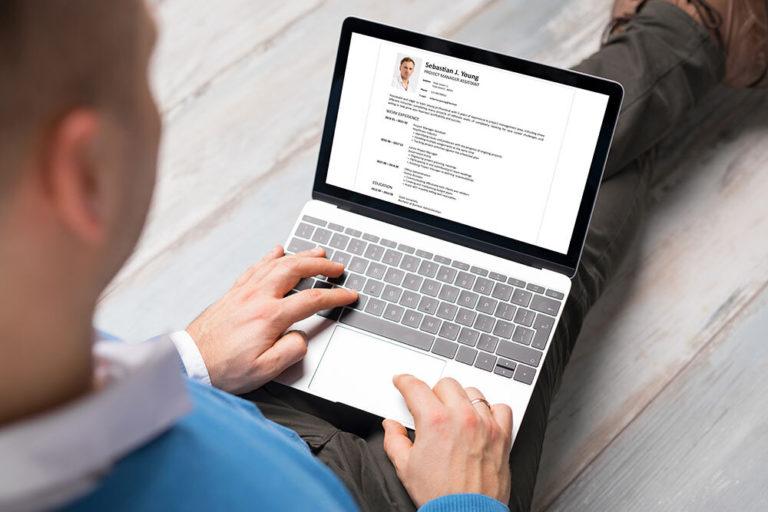 Man creating his CV on laptop. All contents in document are made up.